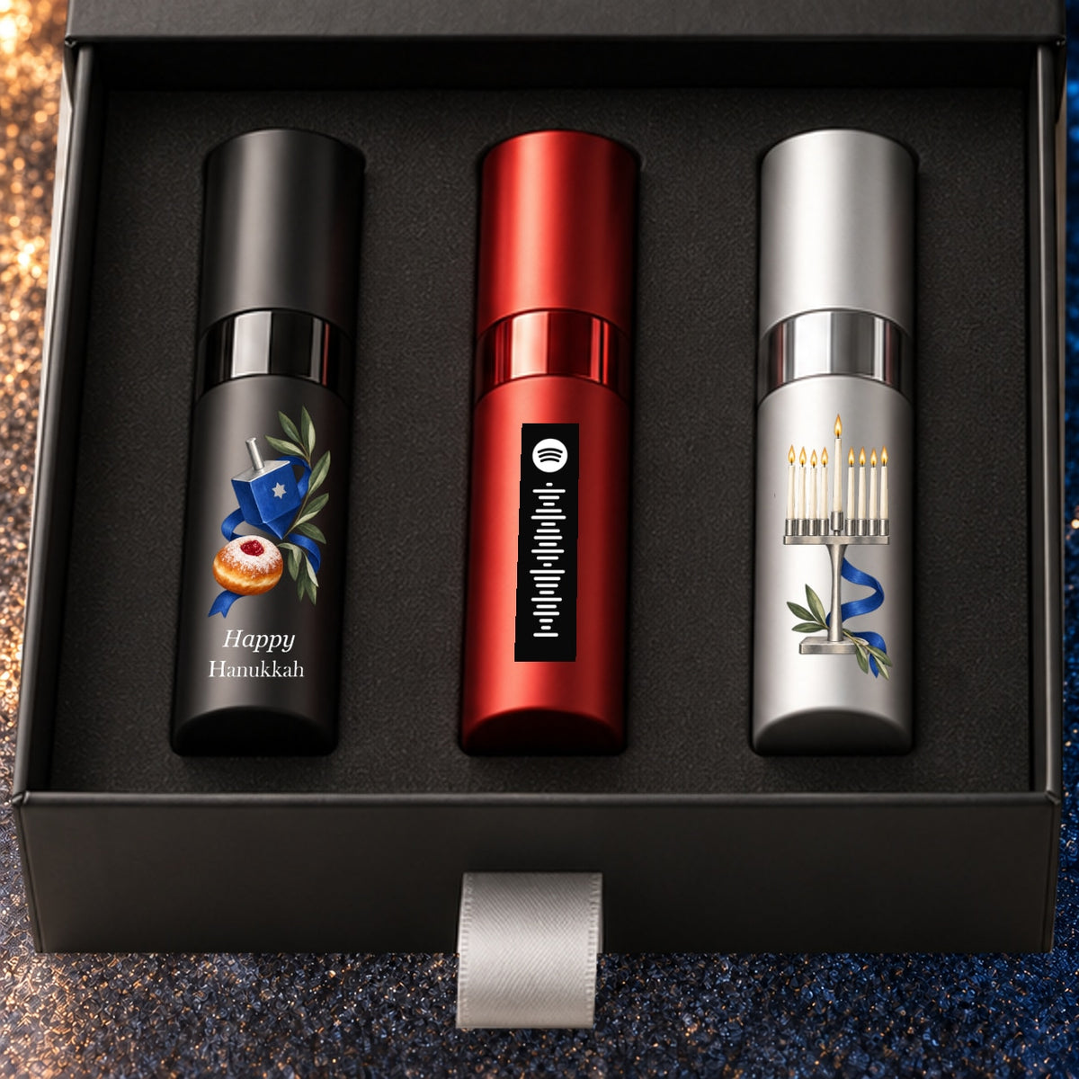 Hanukkah Fragrance Gift Set for Him — artwork detail. Black, red and silver atomizers with Hanukkah artwork in the Essentia gift box.