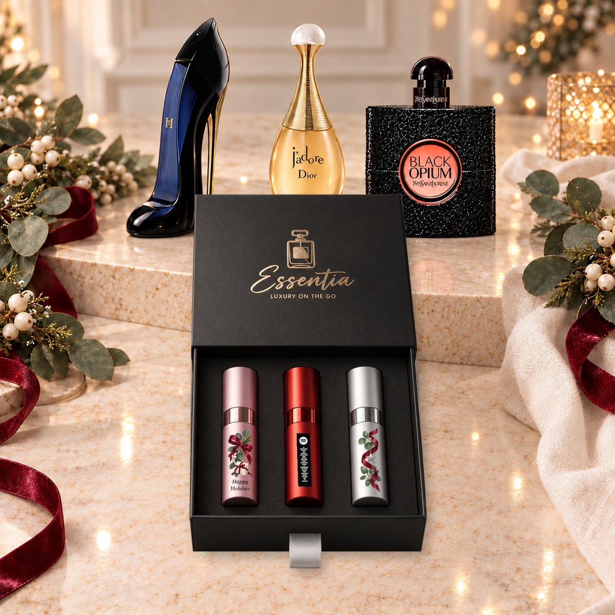 Happy Holidays Fragrance Gift Set for Her — hero. Pink, red and silver atomizers with festive artwork in the Essentia gift box.
