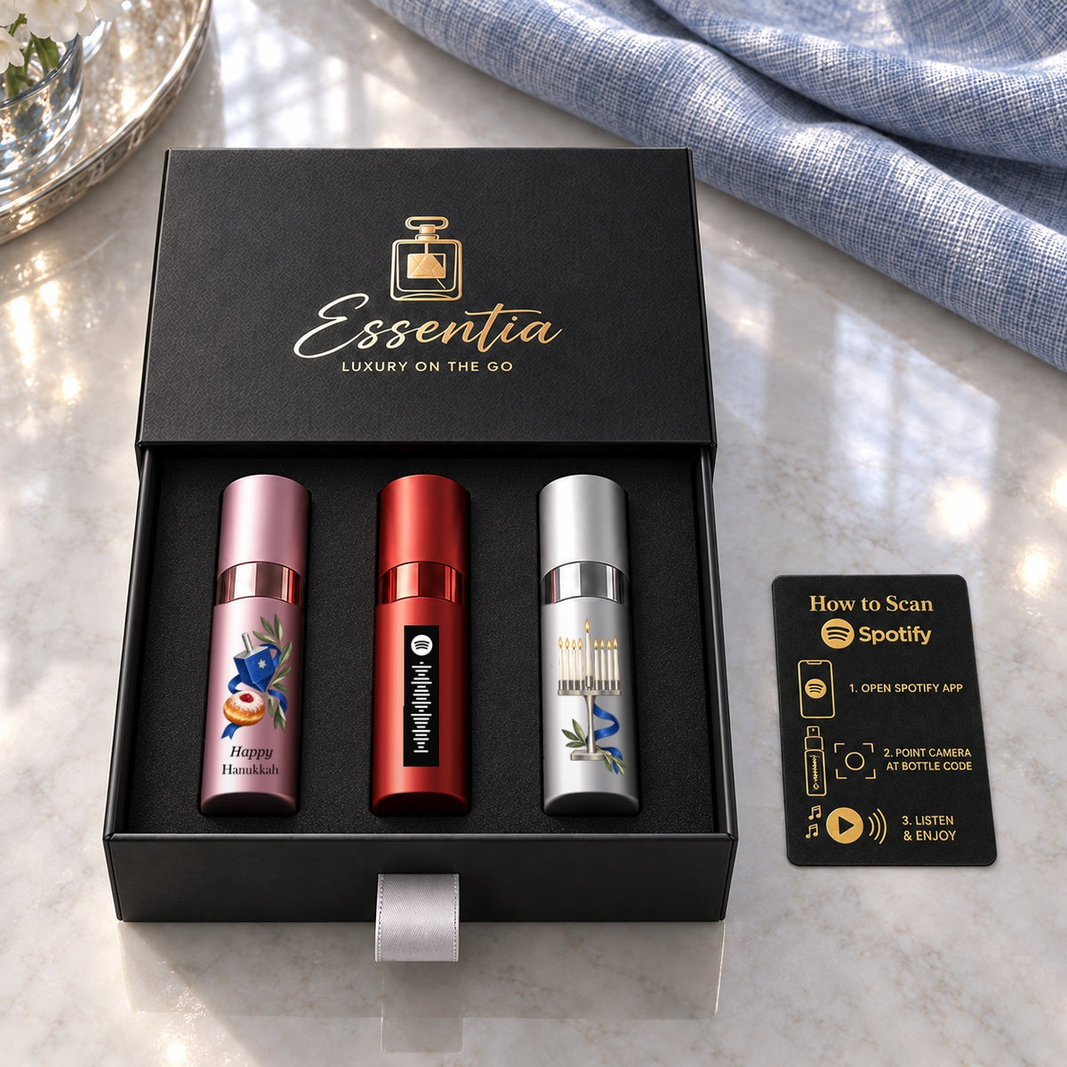 Hanukkah Fragrance Gift Set for Her — included contents. Original black Happy Hanukkah lettering on the pink atomizer and aligned shared motif.