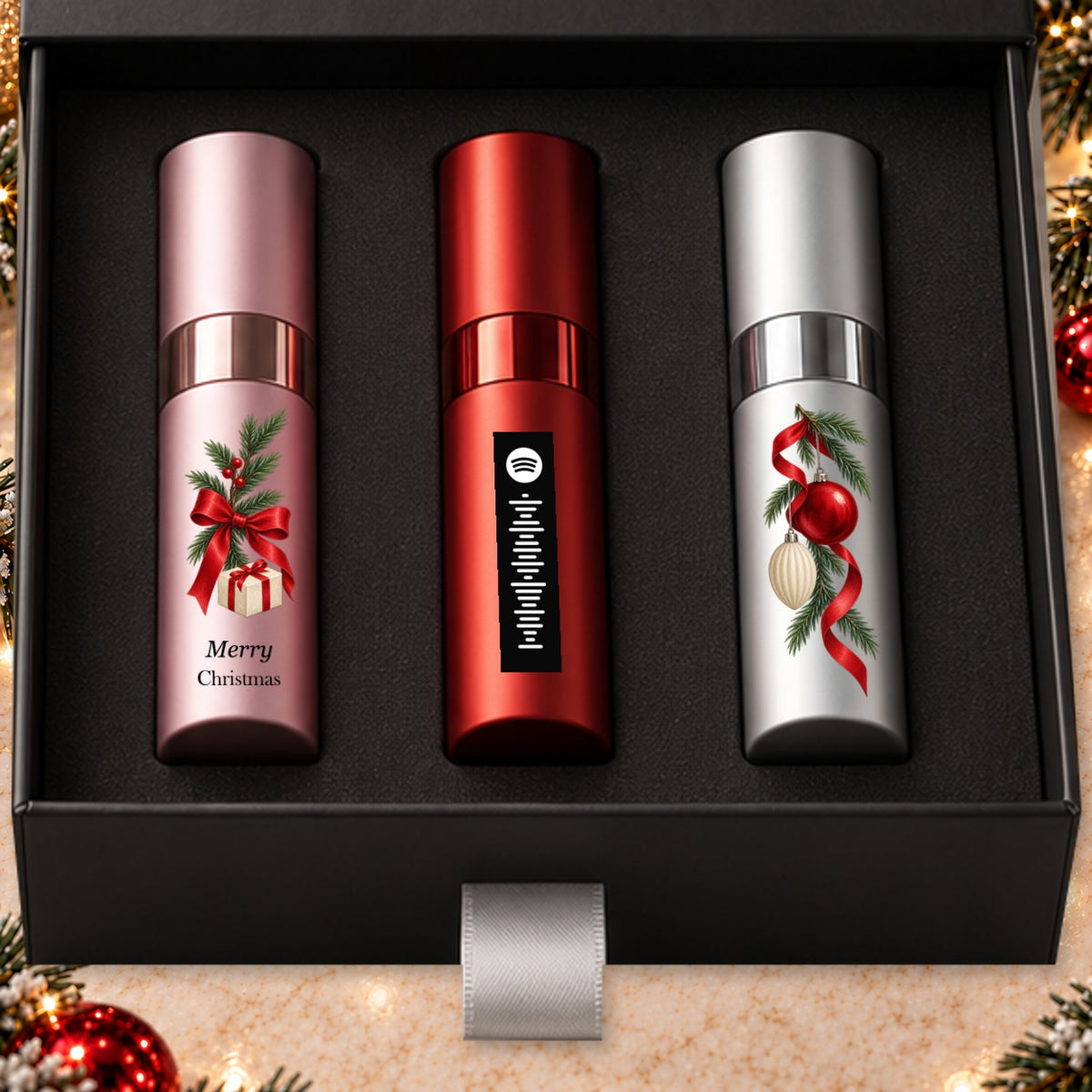 Christmas Fragrance Gift Set for Her — artwork detail. Pink, red and silver atomizers with Christmas artwork in the Essentia gift box.