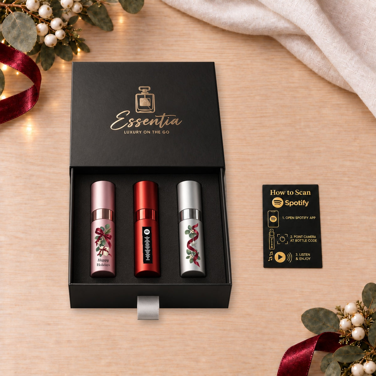 Happy Holidays Fragrance Gift Set for Her — included contents. Pink, red and silver atomizers with festive artwork in the Essentia gift box.
